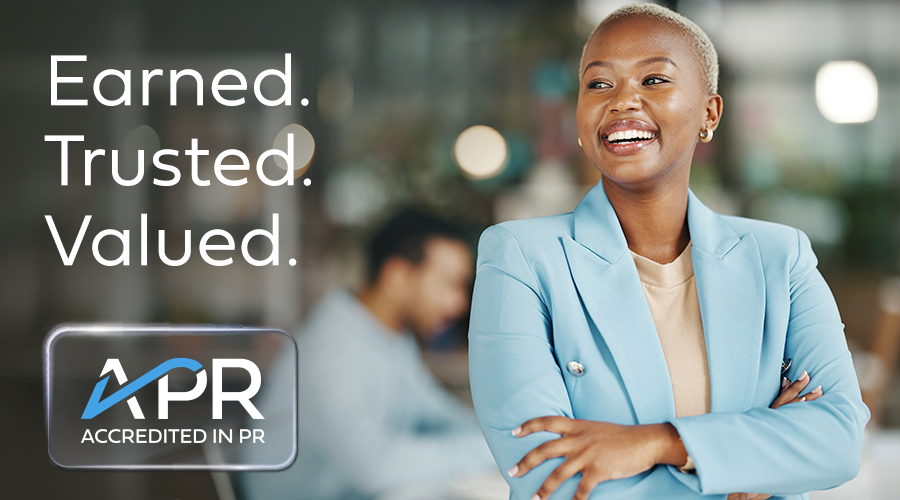 (Photo of a woman smiling in a light blue blazer with her arms folder.) Earned. Trusted. Valued. APR: Accredited in PR.